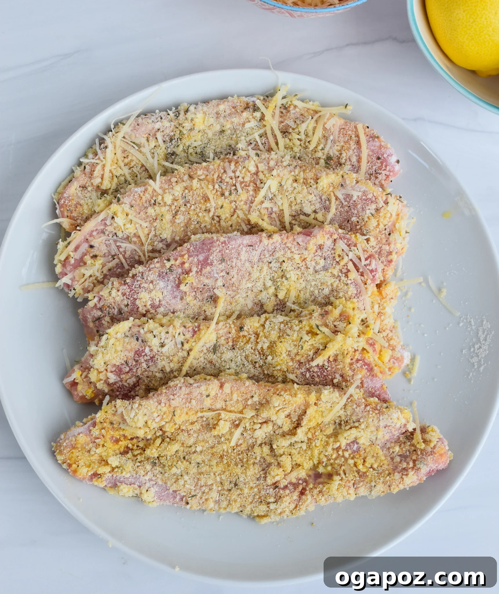 Close-up of veal scaloppine coated in breadcrumbs, ready for Veal Milanese.