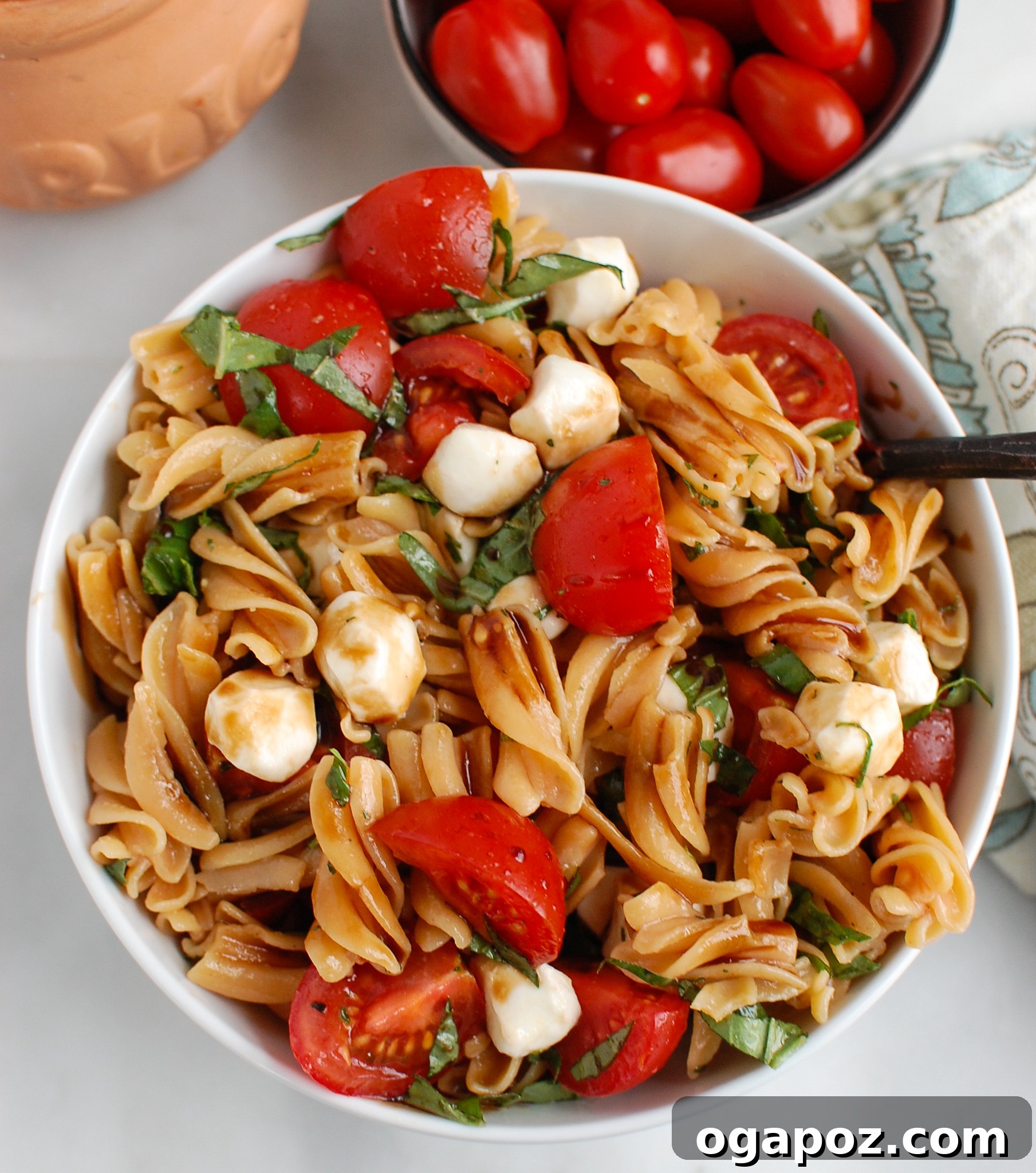 Vibrant Caprese Pasta 5 A serving of Caprese Pasta with a spoon, highlighting the fresh ingredients.
