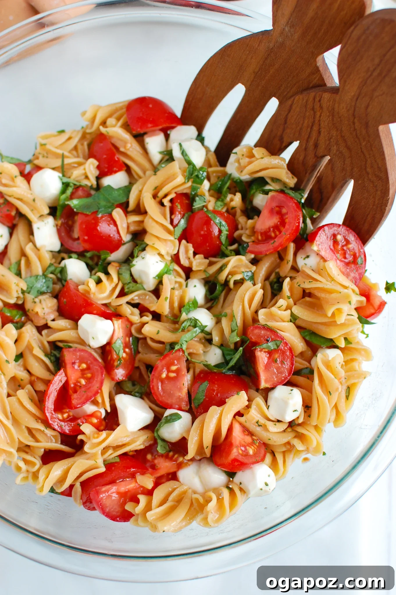 Vibrant Caprese Pasta 6 Caprese Pasta served with wooden tongs, ready to be enjoyed.
