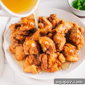 Better Than Takeout Lemon Chicken At Home 5 Lemon chicken on a plate with the lemon chicken sauce being poured over it.