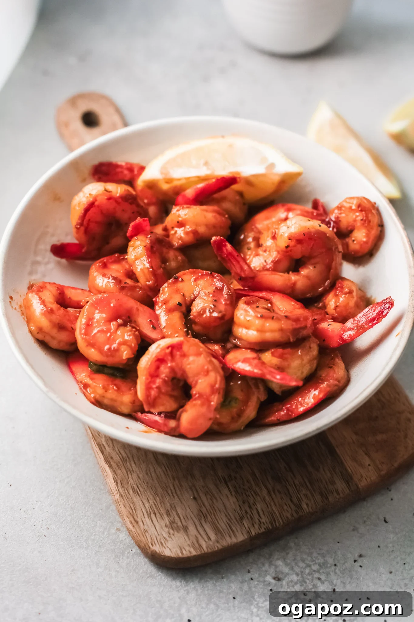 Spicy Southern Shrimp in Minutes 2 Easy Cajun Shrimp Recipe served with a lemon wedge and fresh herbs on a rustic wooden surface.