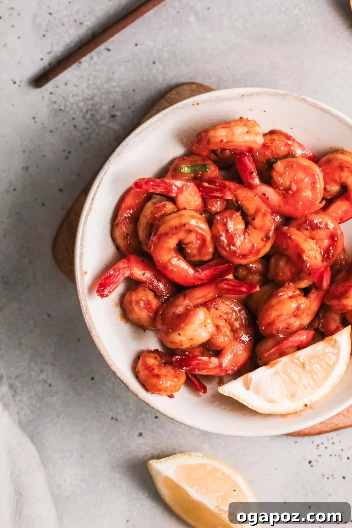 Spicy Southern Shrimp in Minutes 7 Easy Cajun Shrimp Recipe served in a white bowl with fresh lemon slices and a sprinkle of herbs.