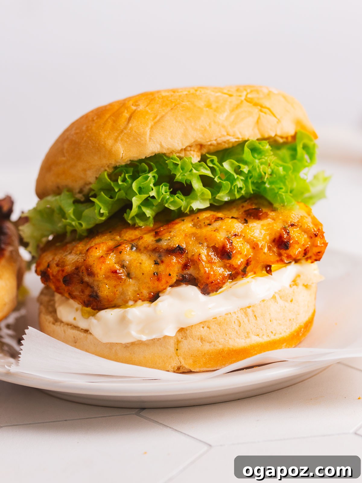 Juicy Homemade Turkey Burgers 2 Perfectly cooked turkey burger on a plate with parchment paper, ready to be served.