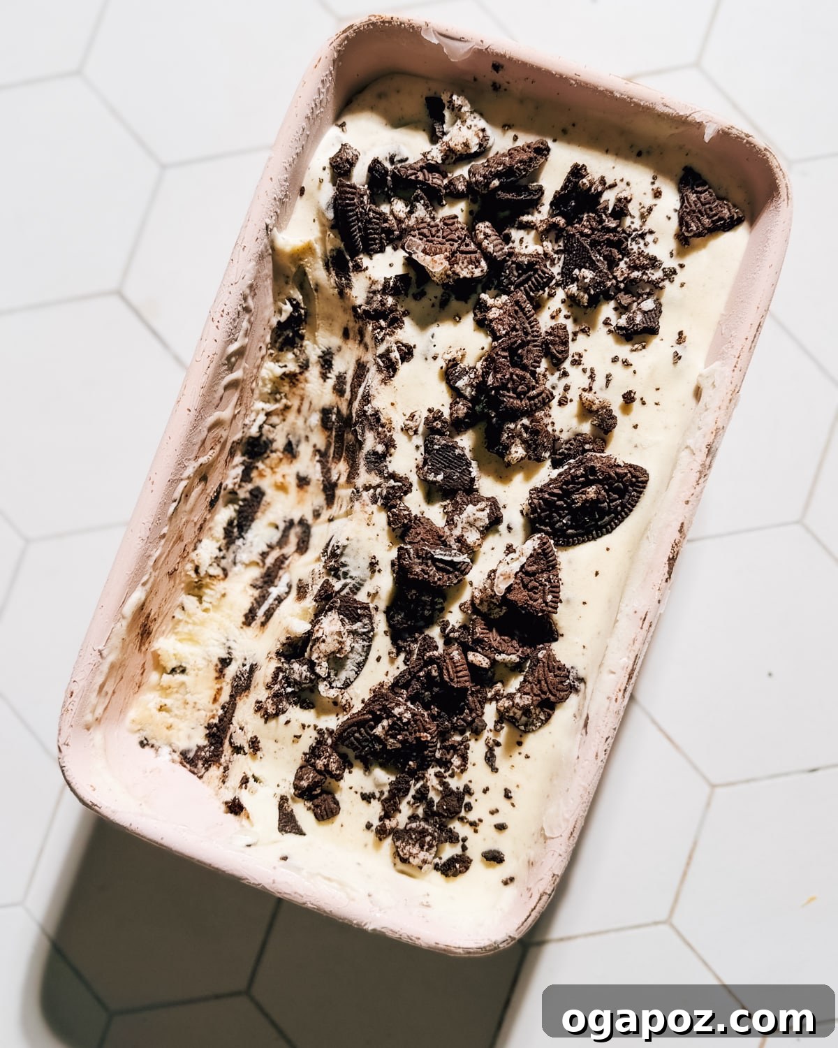 Effortless No Churn Cookies and Cream Ice Cream 4 A scoop of cookies and cream ice cream served elegantly on a white plate, showing the creamy texture and cookie pieces.