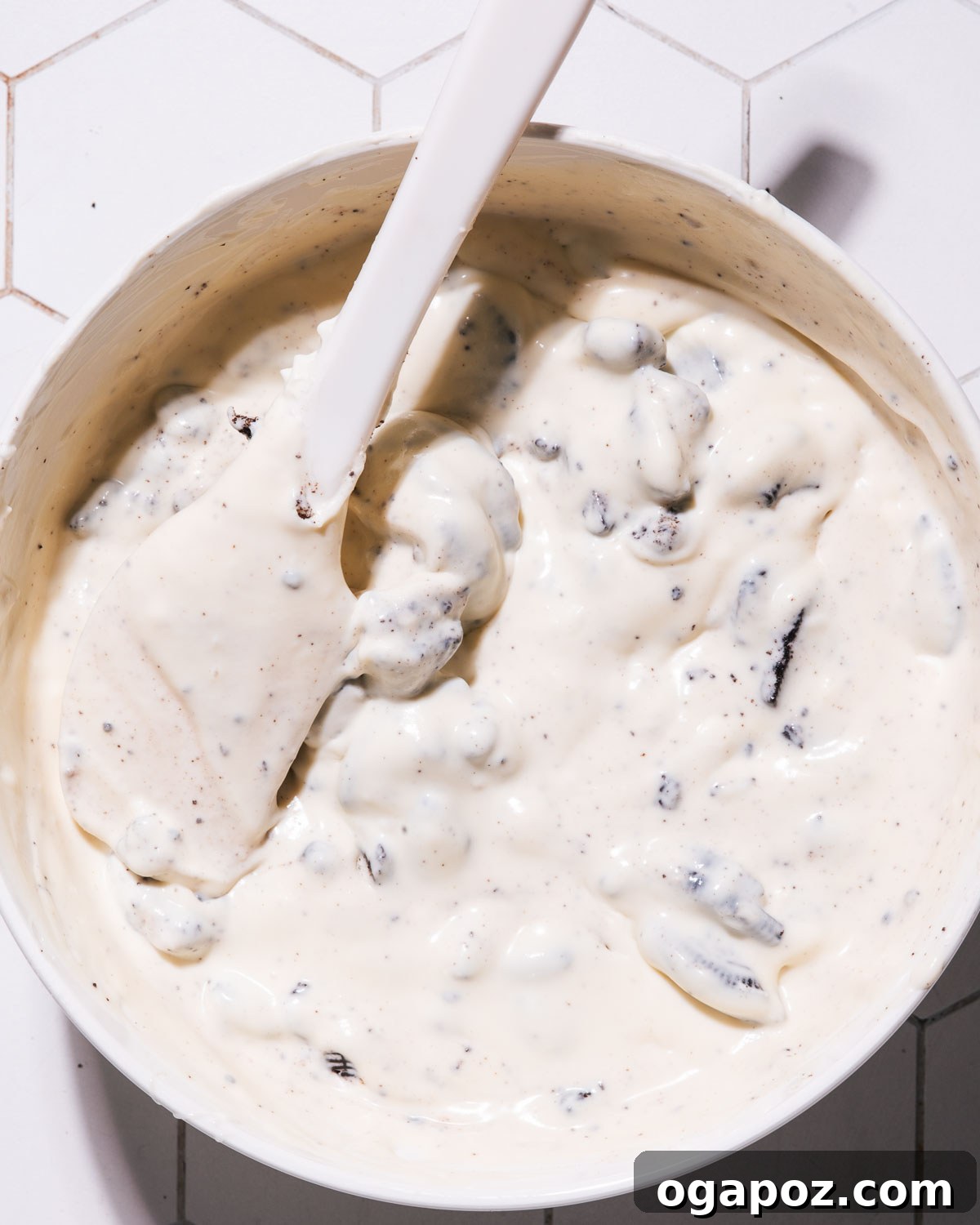Effortless No Churn Cookies and Cream Ice Cream 7 The process of mixing crushed Oreo cookies into the creamy ice cream base.