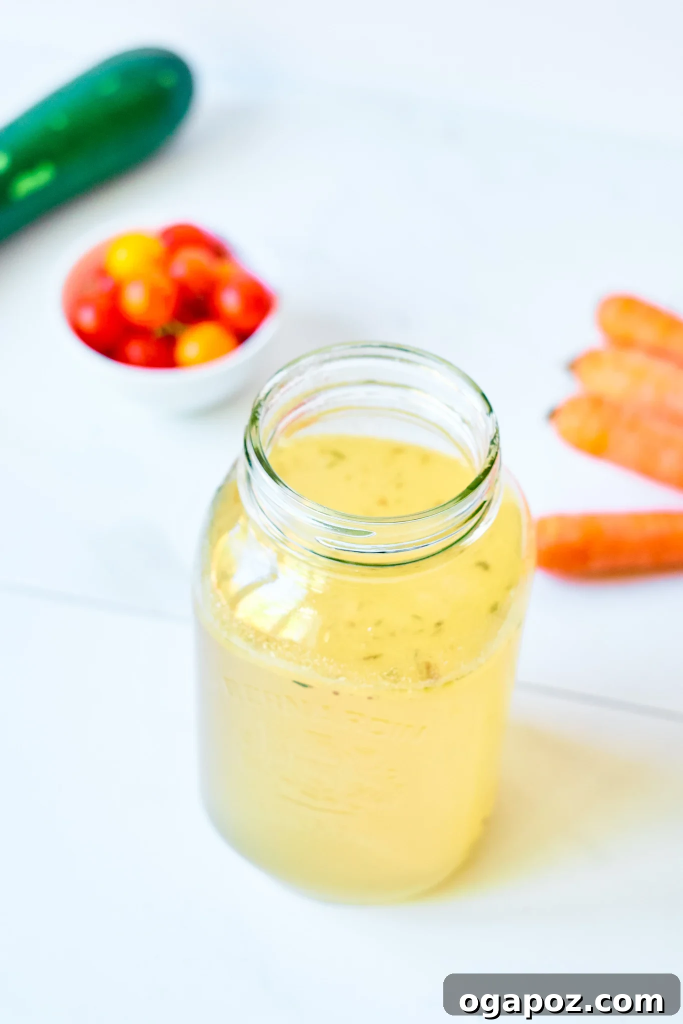 Nourishing Beef Bone Broth Made Simple 2 Easy Beef Bone Broth Recipe in jar, garnished with herbs.