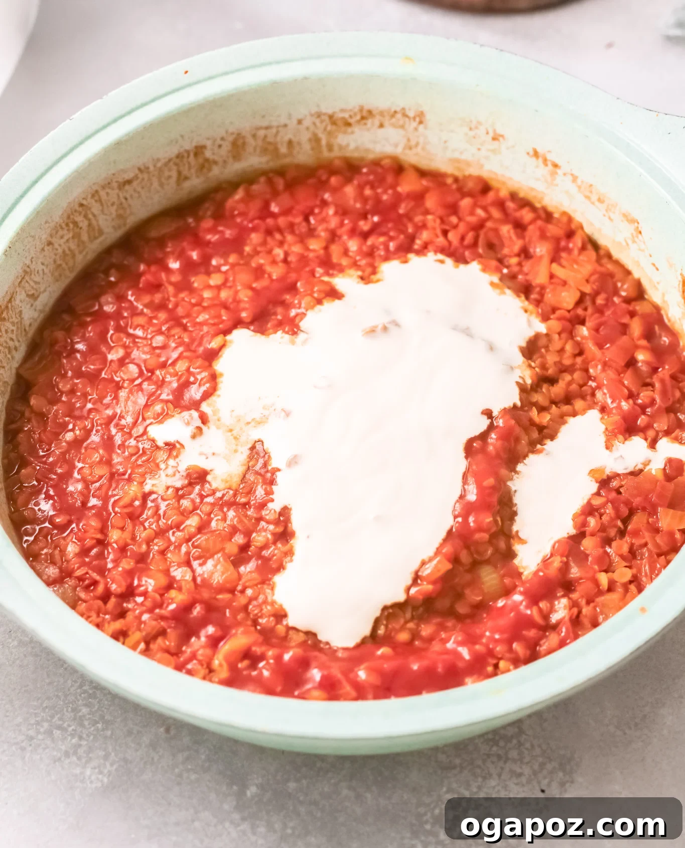 Spiced Red Lentil Curry 8 A close-up of creamy Red Lentil Curry in a pot after coconut cream has been stirred in, showing its smooth and rich texture.