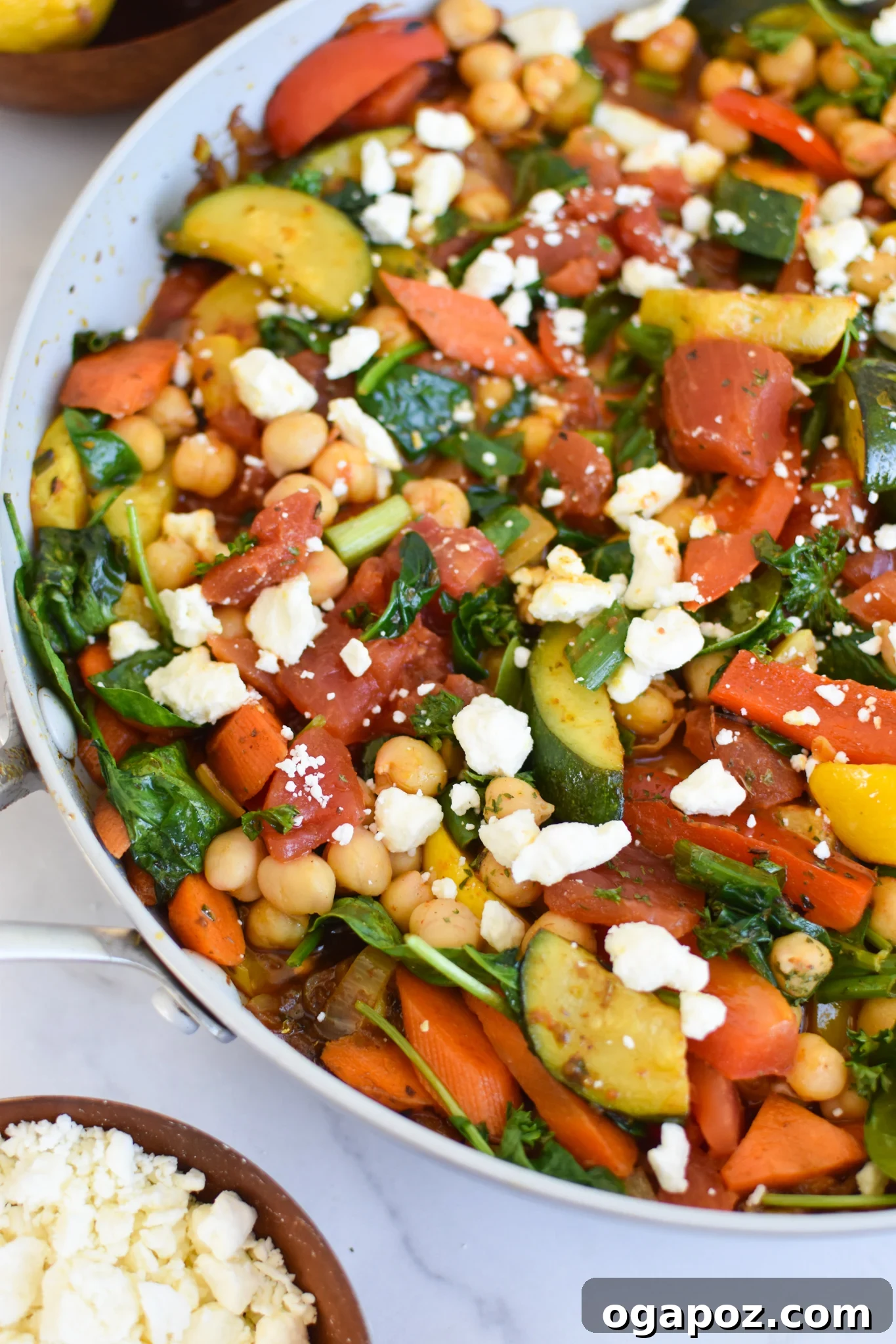 Vibrant Mediterranean Chickpea Skillet 5 Mediterranean Chickpea Skillet actively cooking in a large cast-iron pan, showcasing the rich colors and textures.