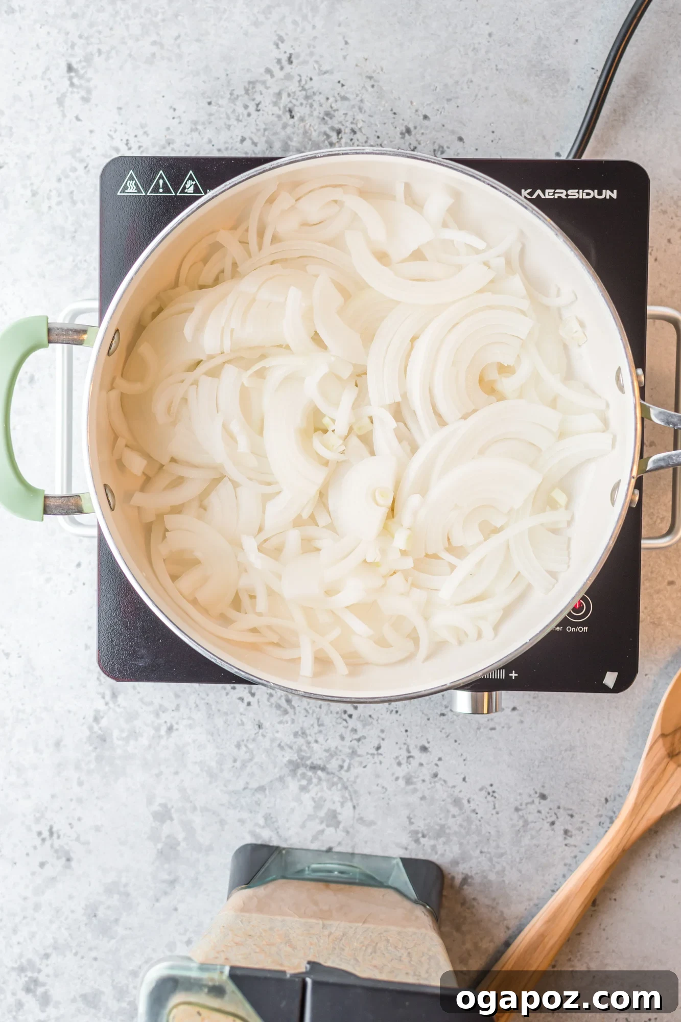 Sliced onions sautéing in a pan for Chicken Tinga.