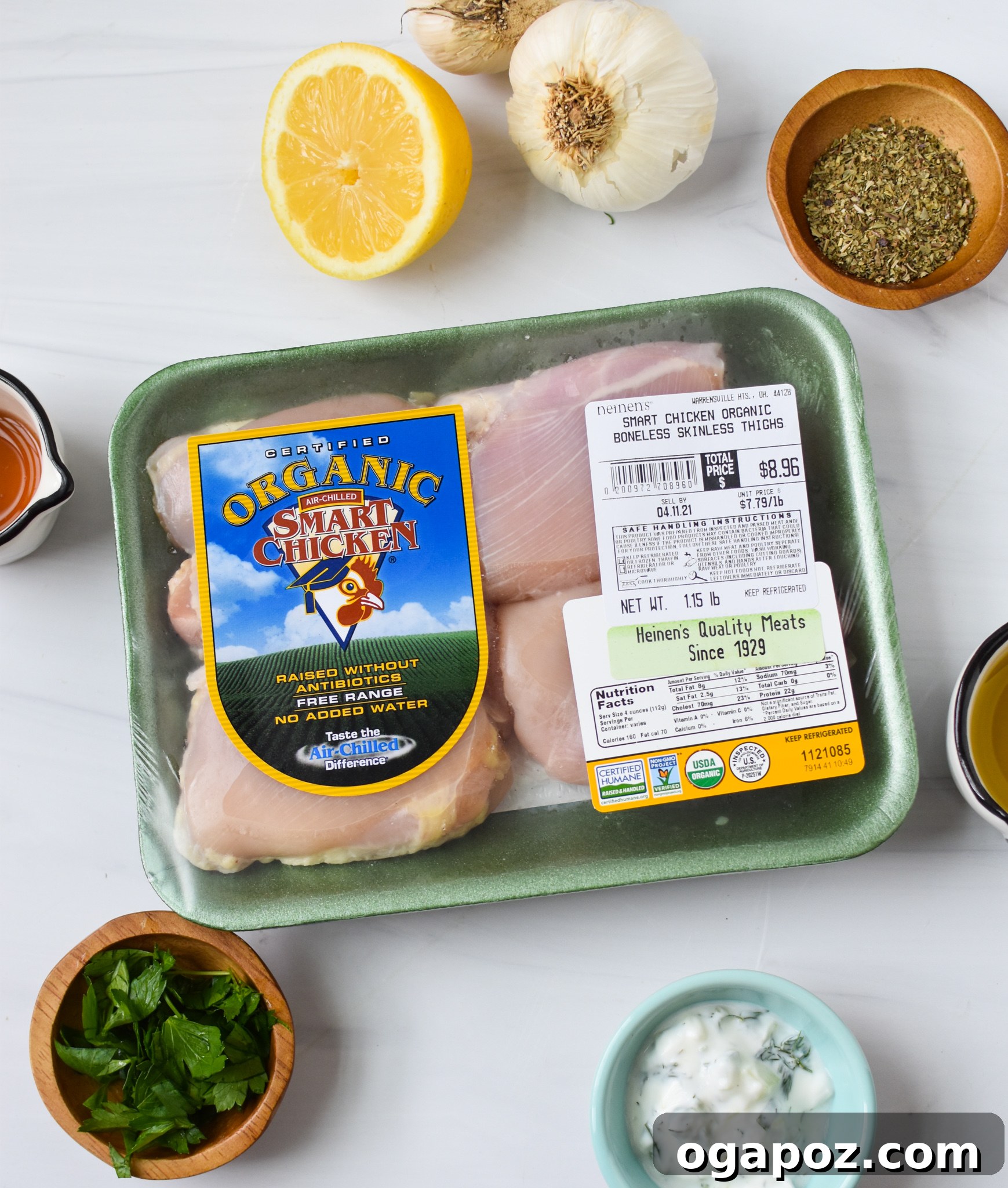 Classic Greek Chicken Souvlaki 3 A selection of fresh ingredients including chicken thighs, lemons, olive oil, garlic, and spices, laid out for a Chicken Souvlaki recipe.