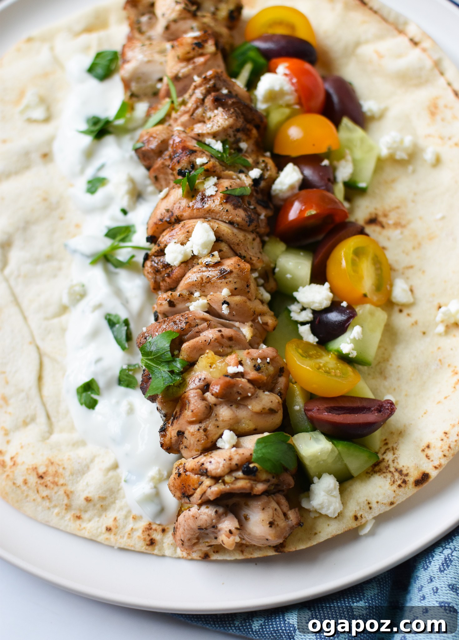 Classic Greek Chicken Souvlaki 4 Chicken Souvlaki Skewers served on a white platter with cherry tomatoes, feta cheese, and fresh dill.