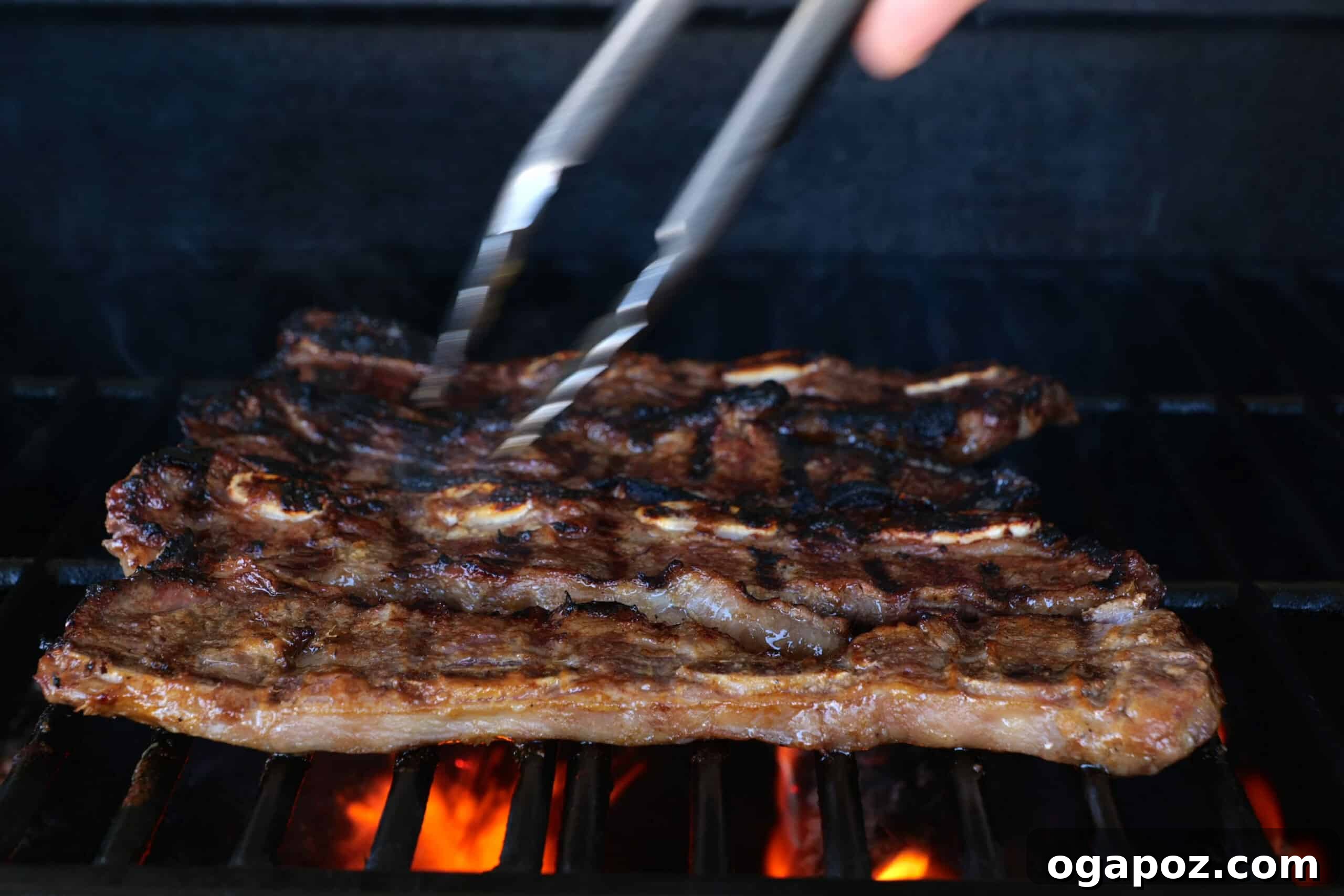 Korean BBQ Galbi 5 Close-up of marinated Korean Short Ribs sizzling on a hot grill, showing perfect sear marks and rich, golden-brown caramelization.
