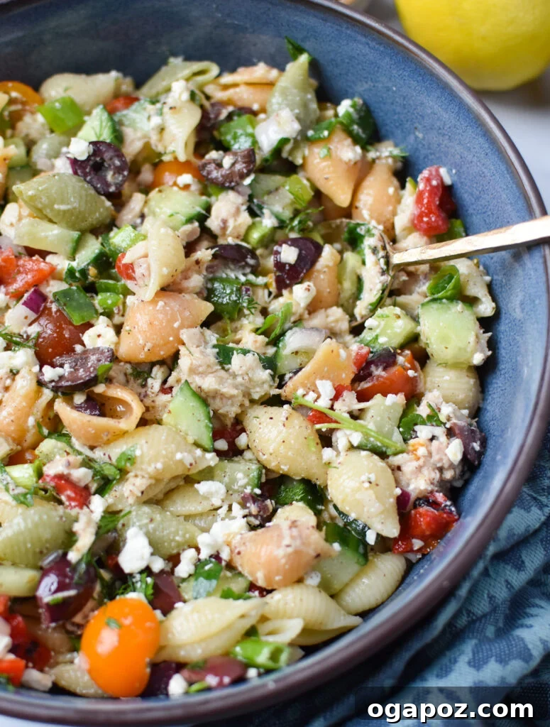 Zesty Mediterranean Tuna Pasta Salad 2 A beautifully presented Mediterranean Tuna Pasta Salad in a bowl, resting on a blue napkin, showcasing its fresh ingredients.