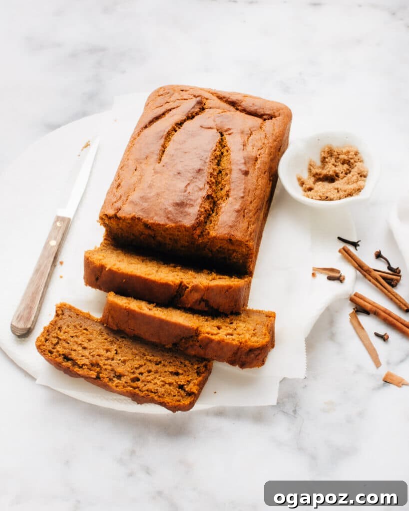 Luscious Autumn Pumpkin Loaf 2 A perfectly sliced loaf of moist pumpkin bread on parchment paper, ready to be enjoyed.