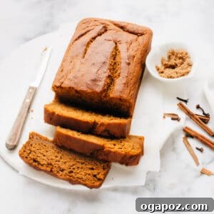 Luscious Autumn Pumpkin Loaf 4 A beautifully baked pumpkin bread, sliced and ready to serve, sitting on parchment paper.