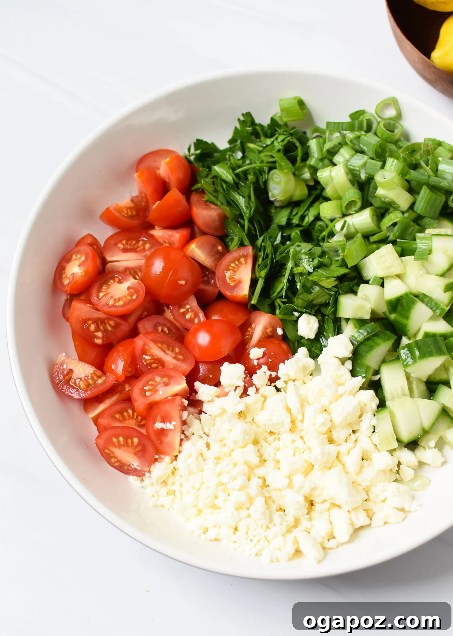Zesty Mediterranean Air Fryer Chicken Thighs 4 Freshly chopped Mediterranean salad ingredients in a mixing bowl, ready to be dressed.