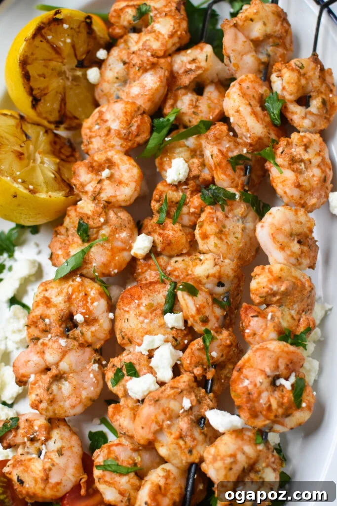 Zesty Mediterranean Grilled Shrimp Skewers 4 Cooked Mediterranean Grilled Shrimp Skewers arranged on a white platter.