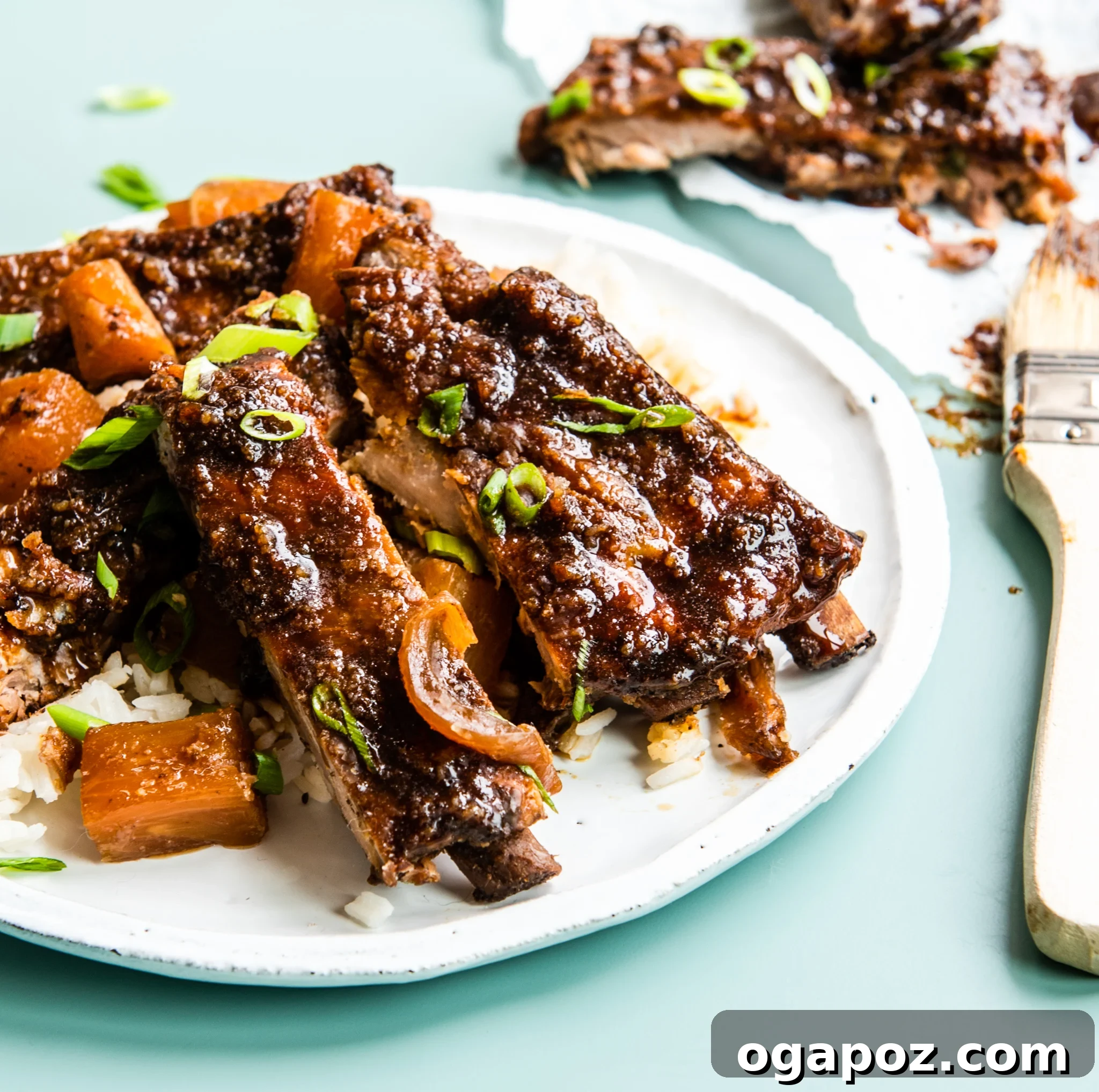 Luau-Inspired Slow Cooker Pork Ribs 2 Plated Slow Cooker Hawaiian Pork Ribs garnished with green onions and pineapple, ready to serve.