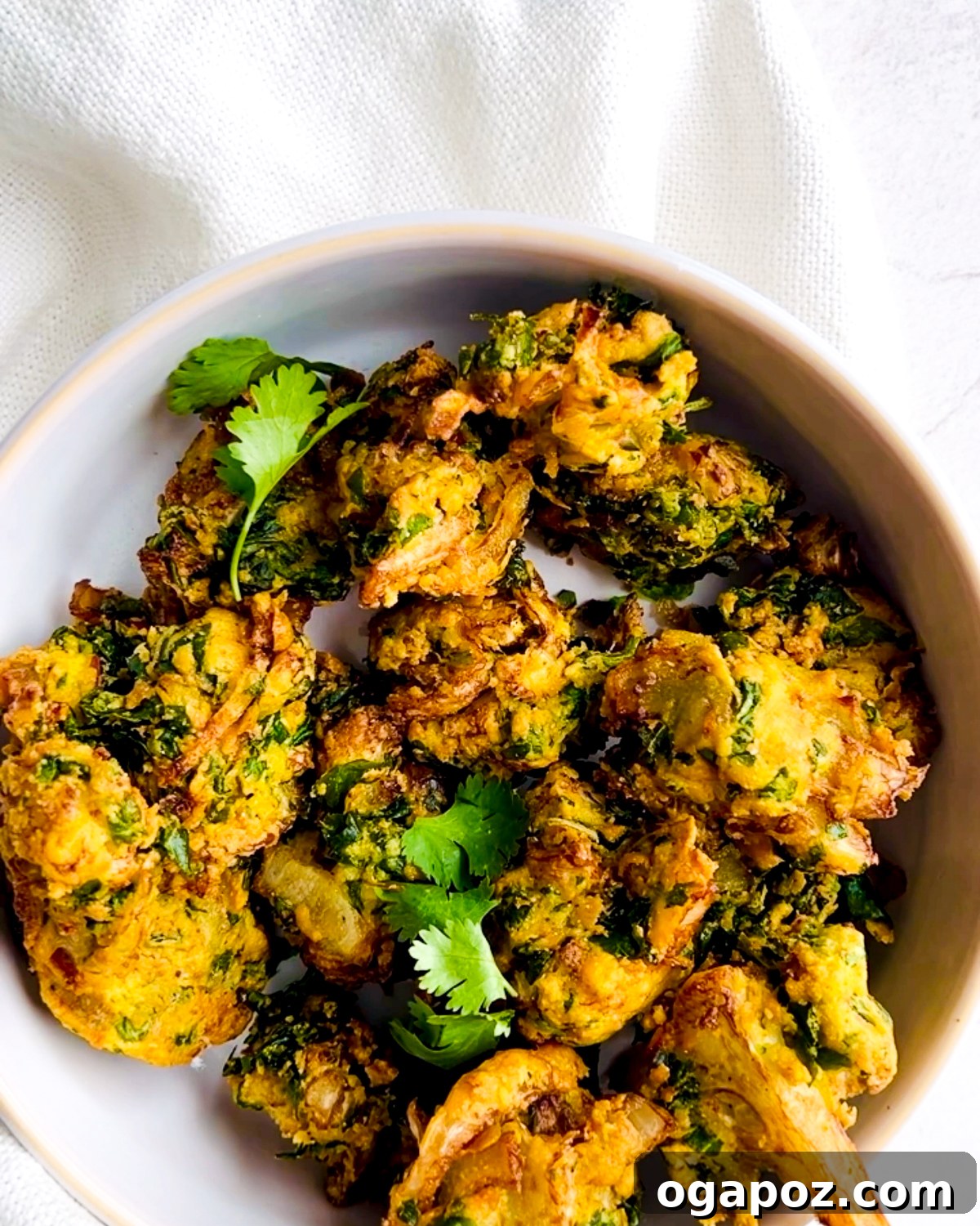 Indian Pakora Effortless Crispy Vegetable Fritters 8 A bowl of freshly fried pakora, garnished with cilantro, ready to be served.
