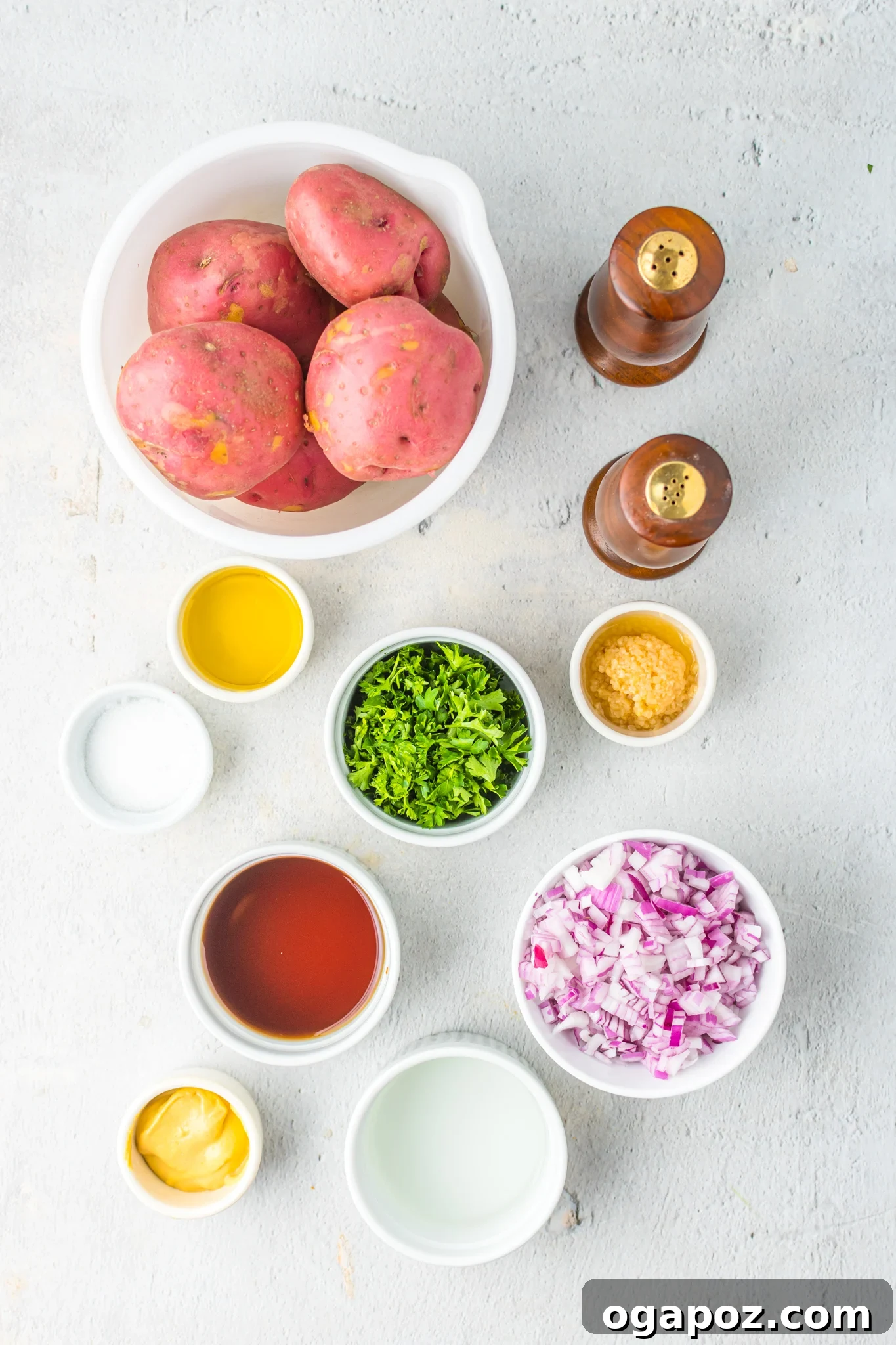 Warm German Potato Salad 3 Fresh ingredients laid out for German Potato Salad recipe, including red potatoes, red onion, garlic, parsley, vinegar, mustard, and bacon.