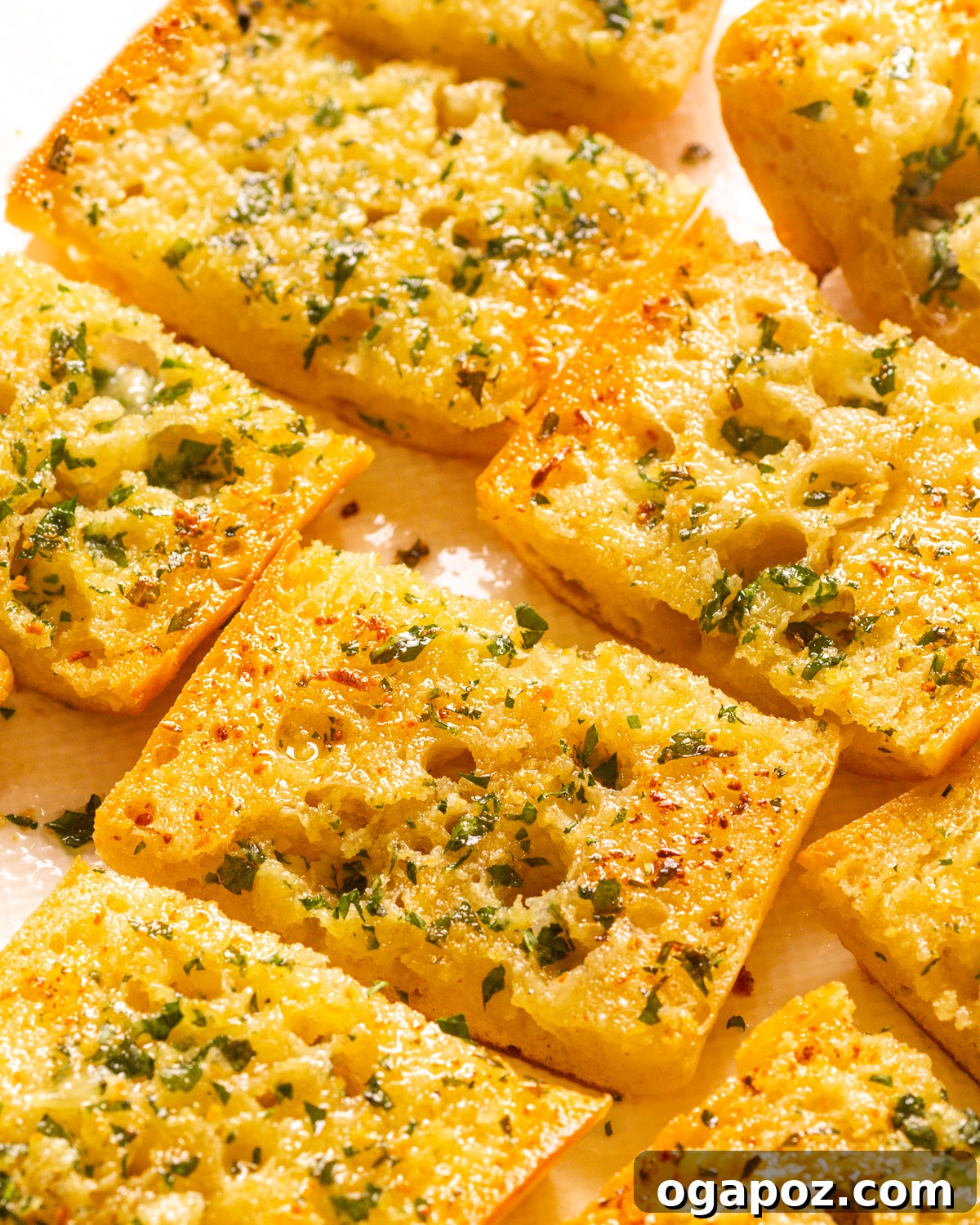 Close-up shot of crispy homemade garlic bread, golden brown and sliced.