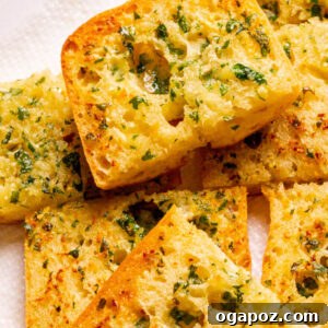 Homemade garlic bread on a plate, golden and sliced.