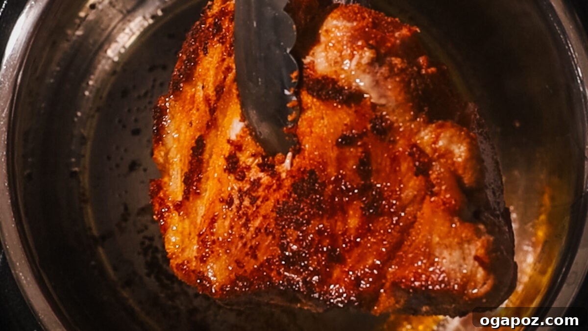 Melt in Your Mouth Instant Pot Pulled Pork 5 Pork searing in the Instant Pot on 'Sauté' mode.