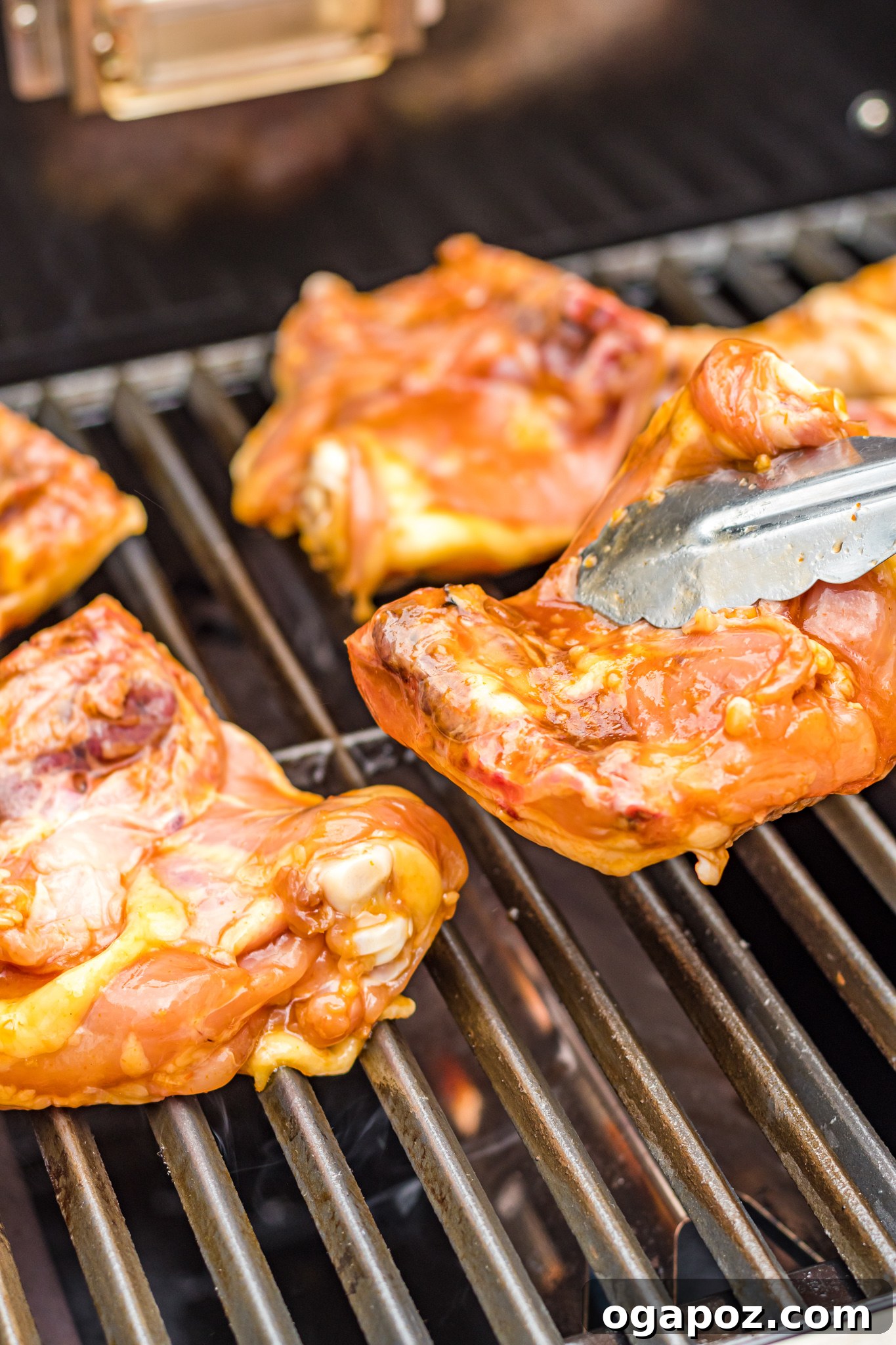 Huli Huli Chicken sizzling on a hot grill, flames licking the tender meat, creating perfect char marks.