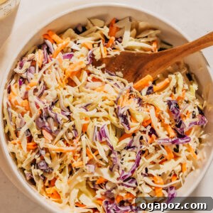 Coleslaw recipe in a bowl with a spoon.