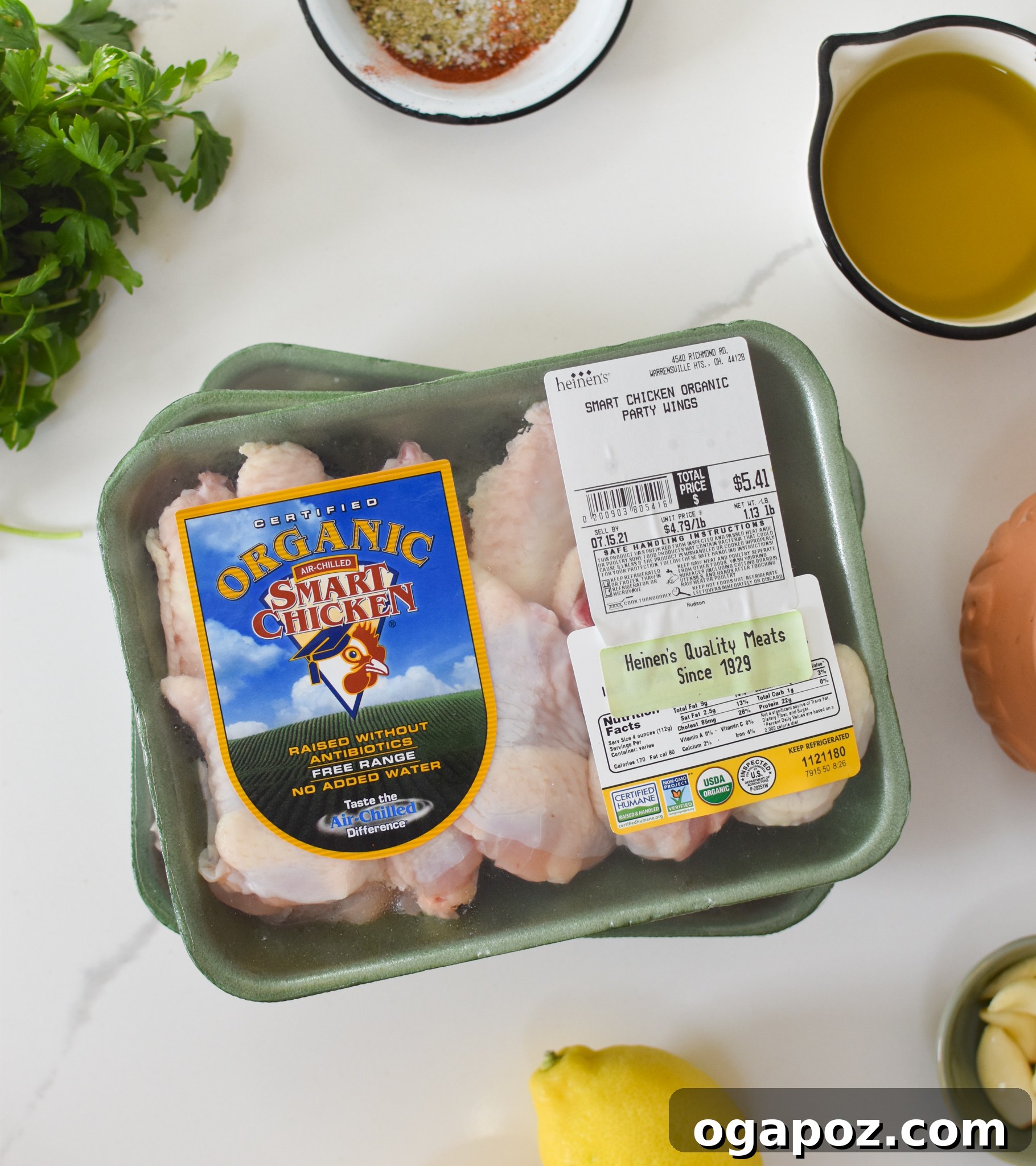 Zesty Mediterranean Grilled Wings 3 Key ingredients for Grilled Mediterranean Chicken Wings laid out on a wooden board: chicken wings, lemon, garlic, olive oil, and various spices.