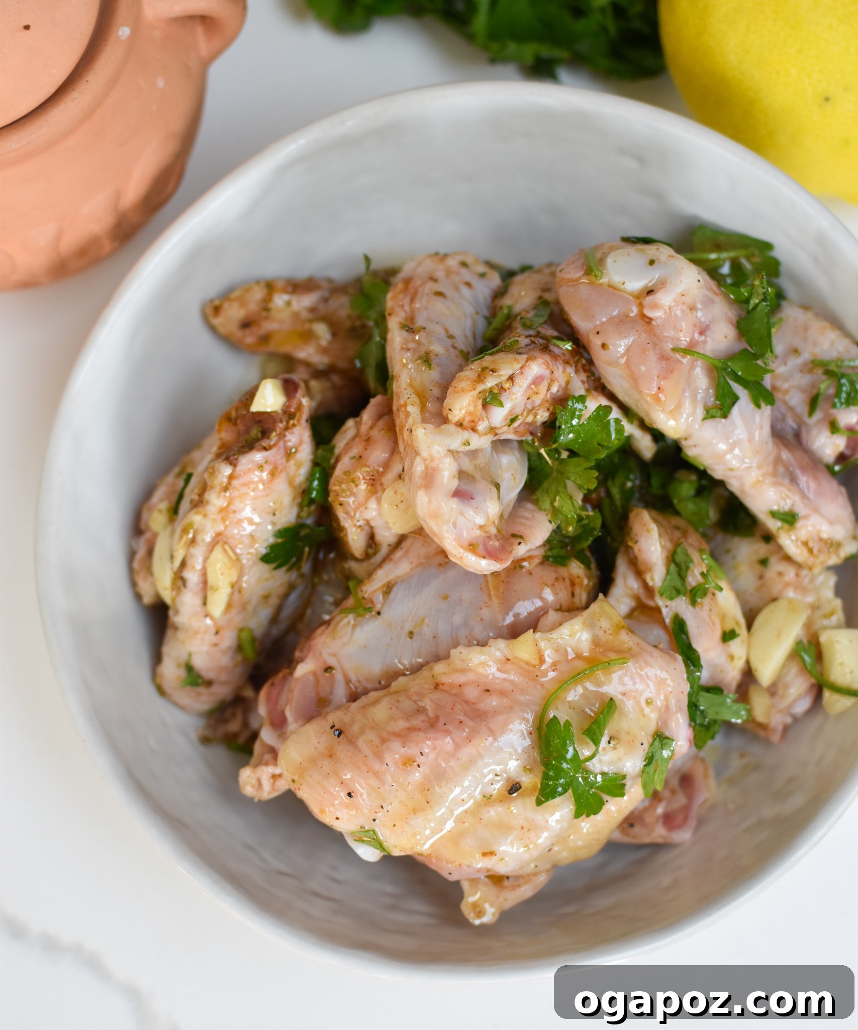 Zesty Mediterranean Grilled Wings 5 Chicken wings soaking in the Mediterranean marinade in a bowl, ready for the grill.