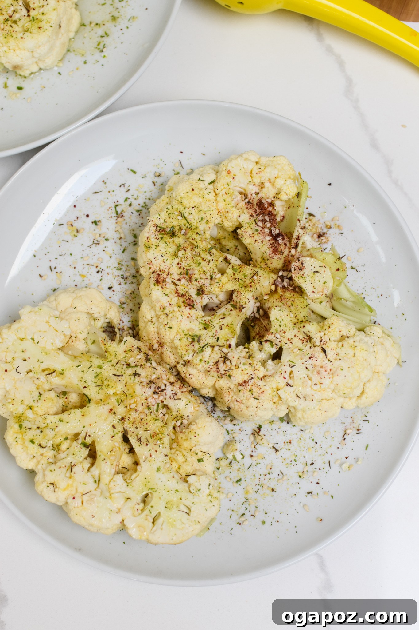 Smoky Grilled Cauliflower Steaks with Creamy Tahini Yogurt 5 Cauliflower steaks being brushed with olive oil and spice mixture before grilling.