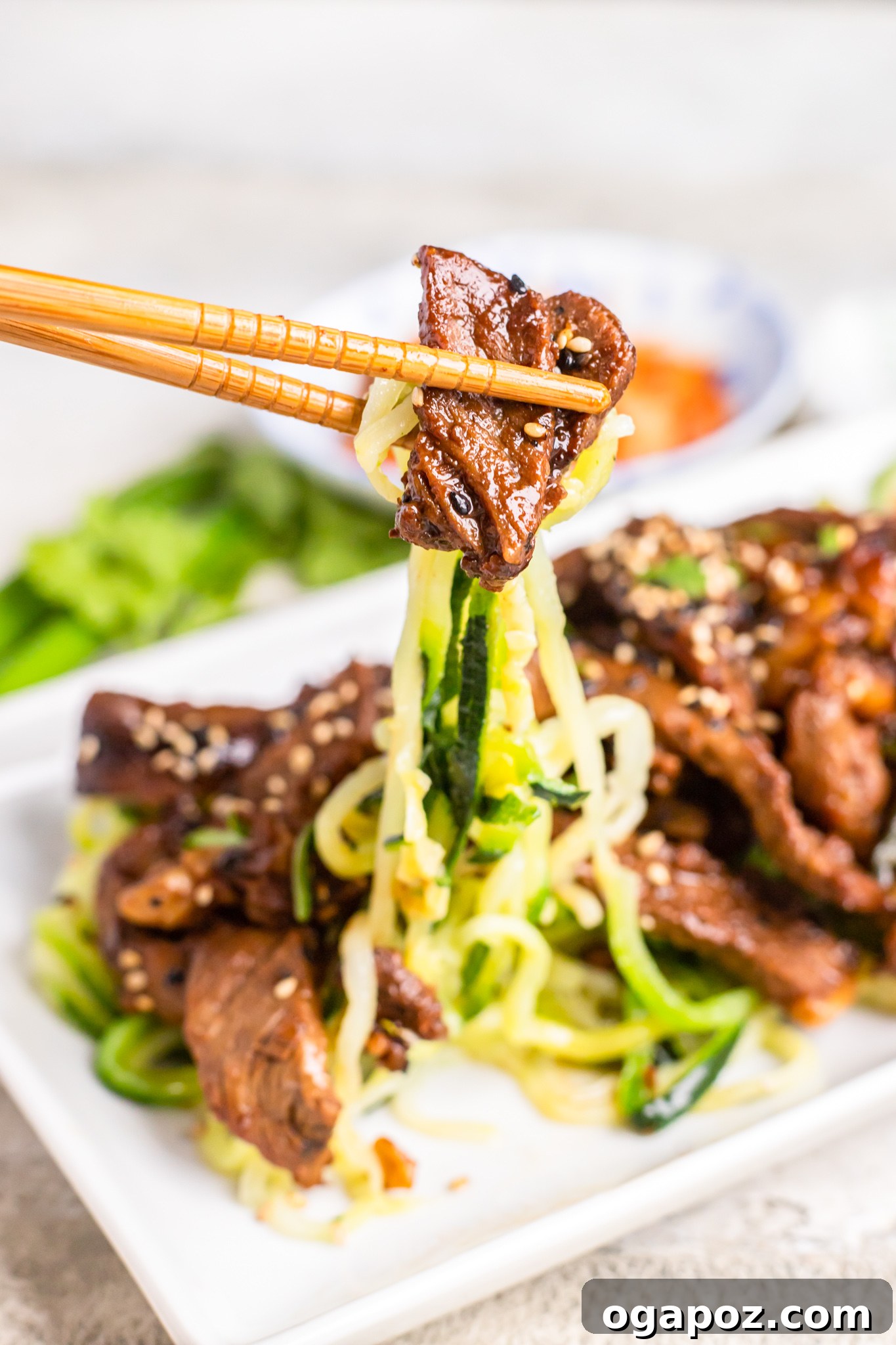 Savory Bulgogi Zucchini Ribbons 3 Beef Bulgogi with Zucchini Noodles being picked up with chopsticks, highlighting the tender beef slices.