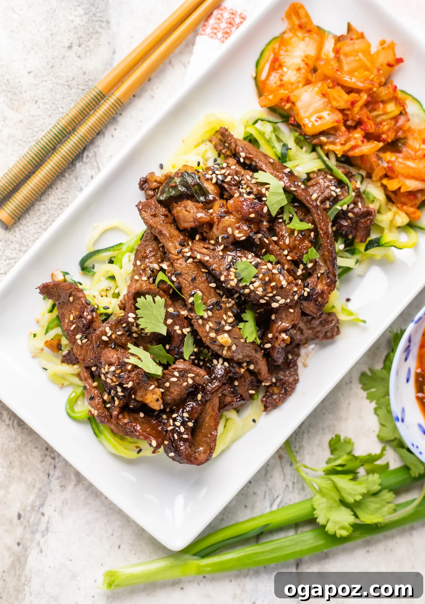 Savory Bulgogi Zucchini Ribbons 6 A serving of Beef Bulgogi with Zucchini Noodles and a side of kimchi, showcasing a complete Korean meal.