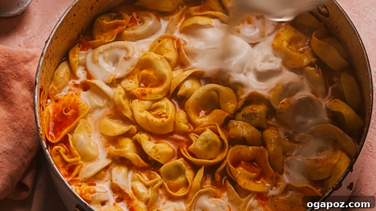 Creamy One-Pot Tortellini Soup 8 Step 5: Heavy cream and spinach stirred into the soup.