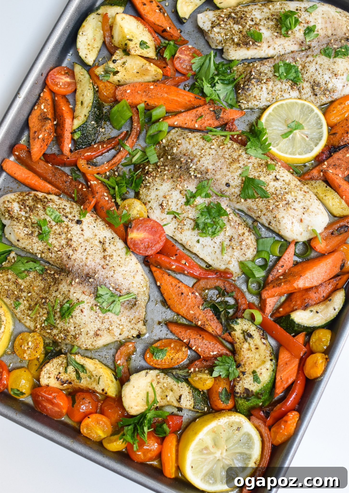 Effortless Mediterranean Baked Tilapia 2 Mediterranean Baked Tilapia on a sheet pan with roasted vegetables.