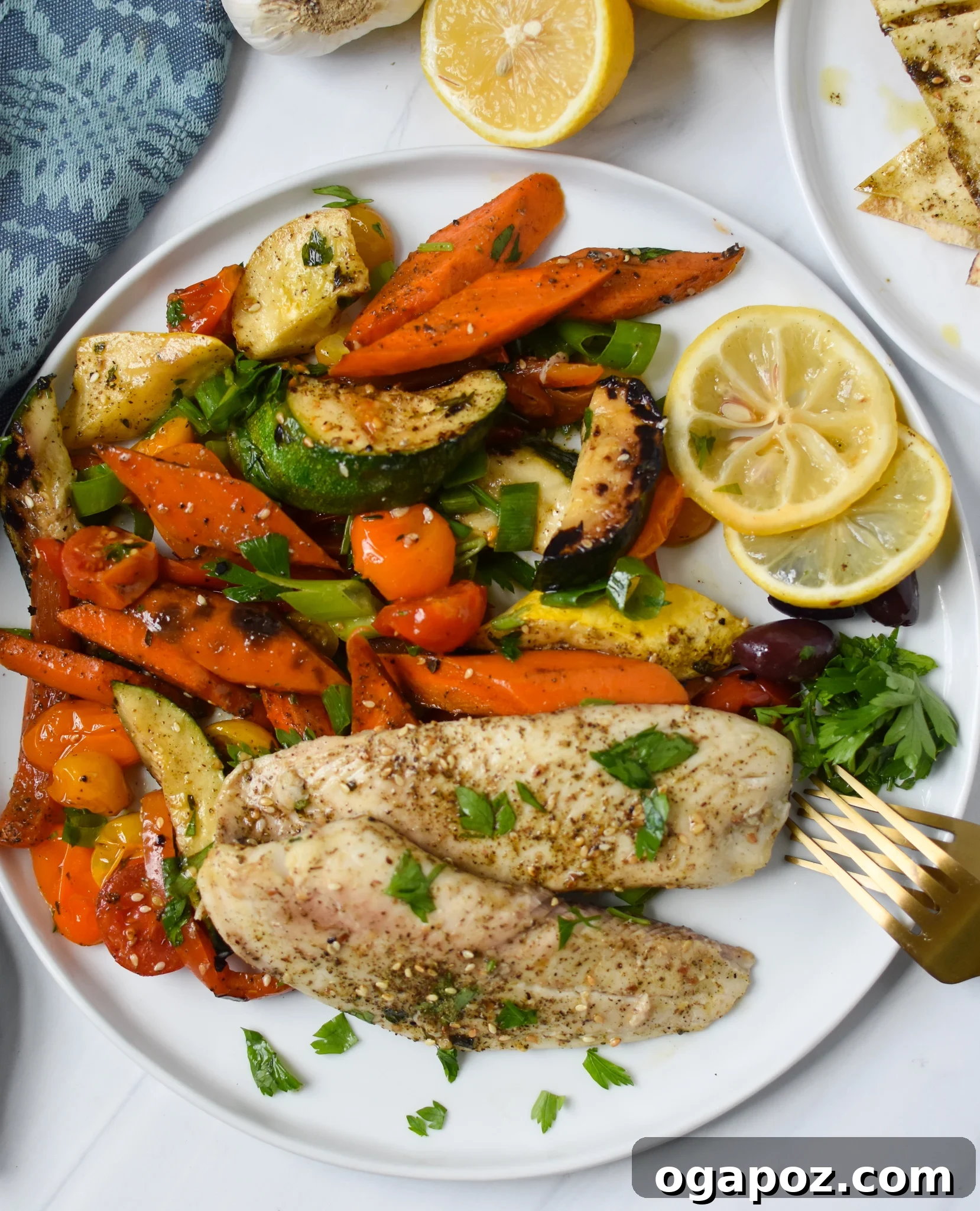 Effortless Mediterranean Baked Tilapia 8 Mediterranean Baked Tilapia Recipe on plate with rice and lemon.