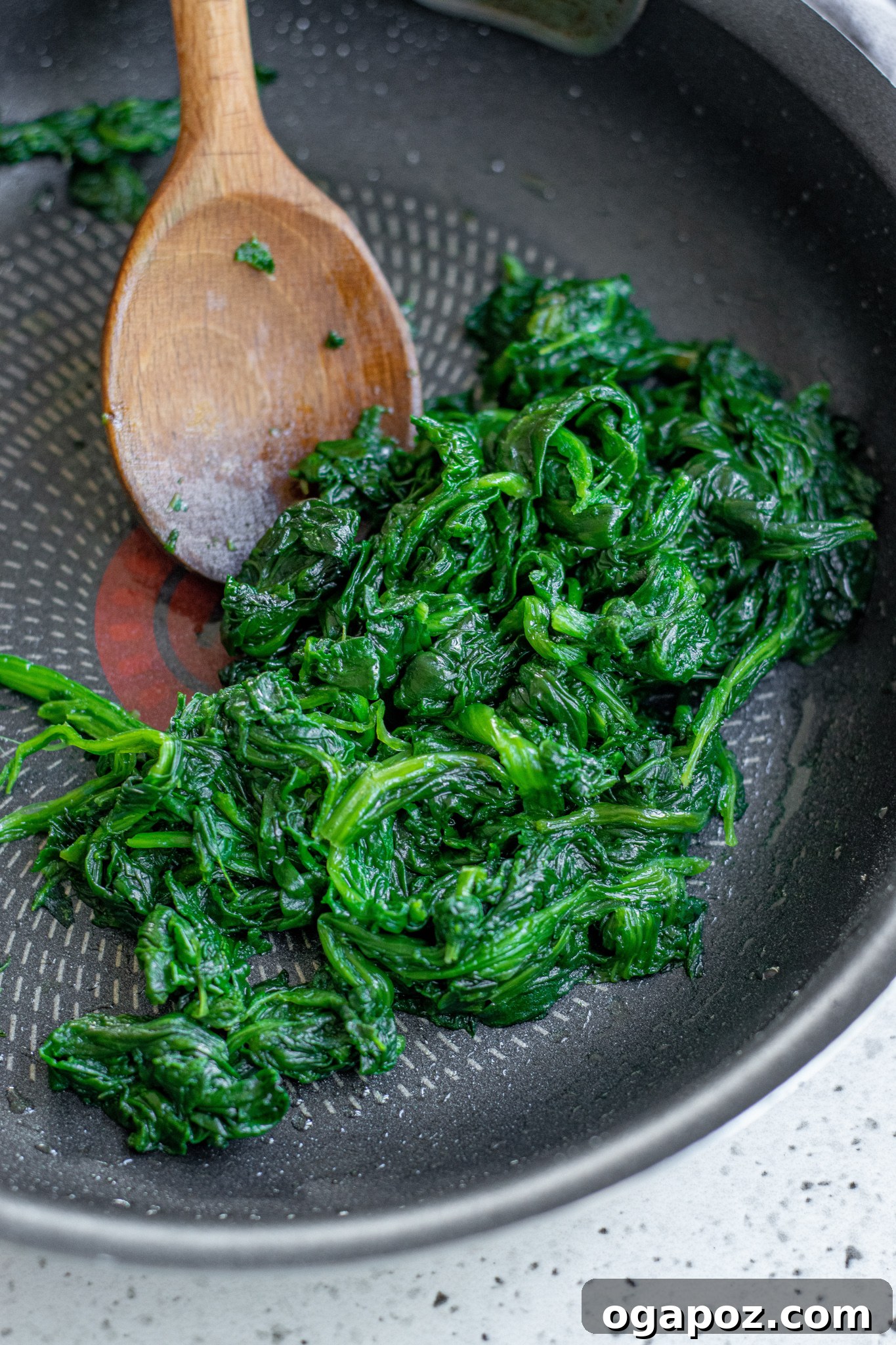 Savory Spinach and Feta Phyllo Pastries 5 Spinach and herb mixture sautéing in a pan for Spanakopita filling.