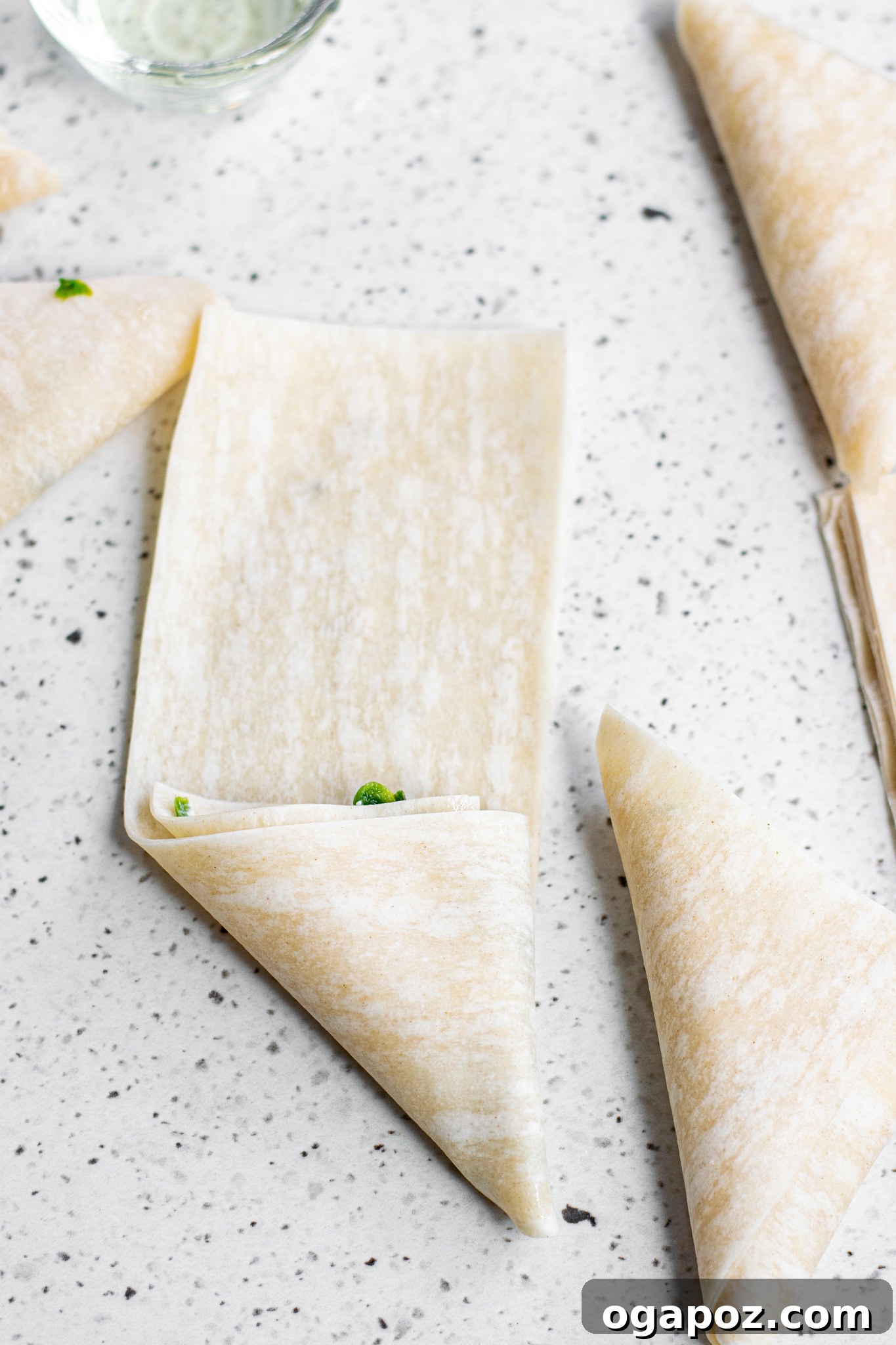 Savory Spinach and Feta Phyllo Pastries 8 Fully folded Spanakopita Triangles ready for baking.