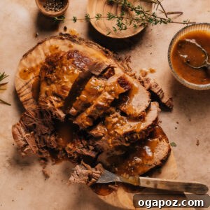 Instant Pot Roast Beef on a cutting board with a bowl of gravy.