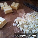 Chopped White Chocolate Chopped white chocolate pieces, precisely cut and ready for melting into a smooth, creamy layer