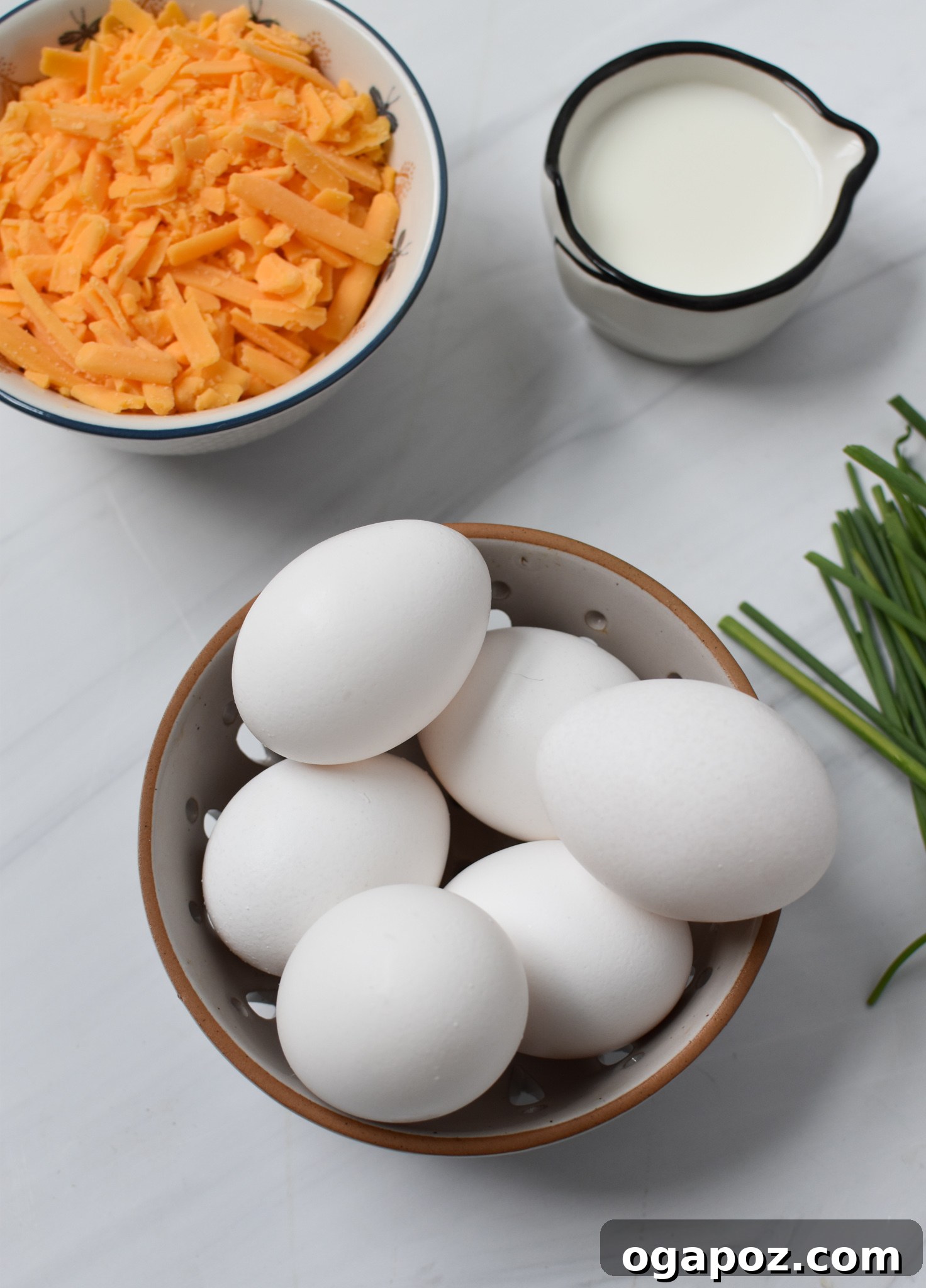 Quick and Easy Chaffles 3 A bowl filled with fresh eggs and a separate bowl of shredded cheddar cheese, showcasing the main ingredients for Chaffles.