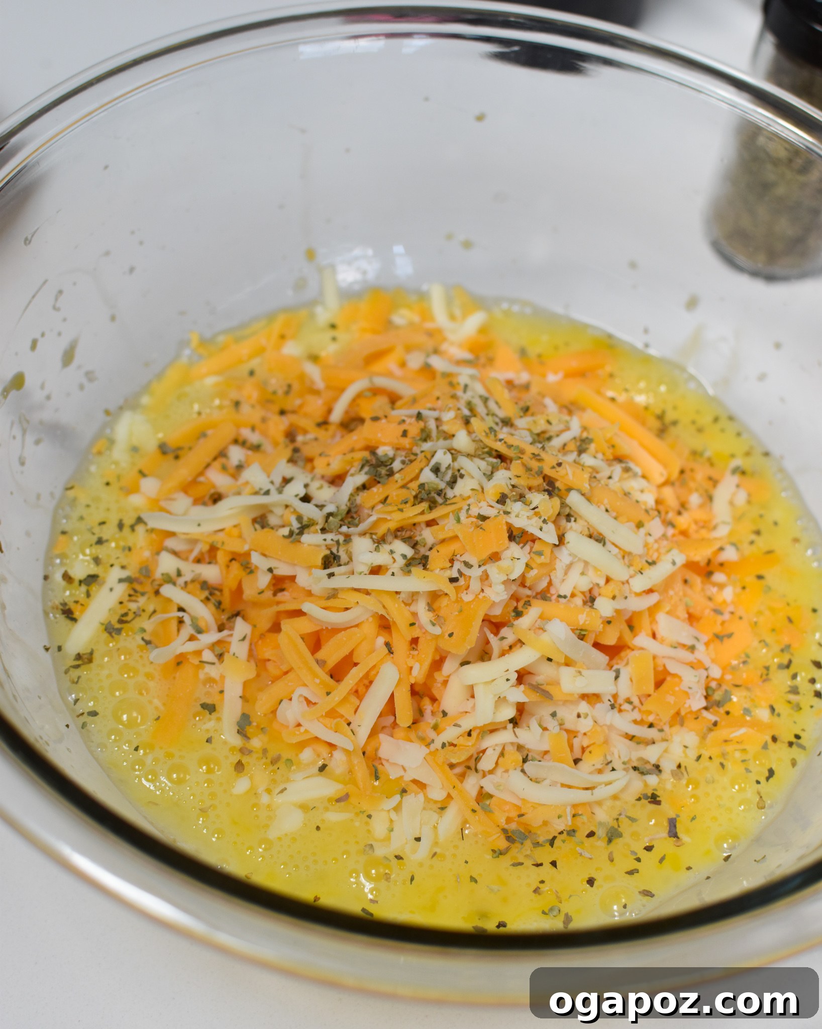 Quick and Easy Chaffles 6 Chaffle batter with whisked eggs and shredded cheese combined in a bowl, ready for seasoning.