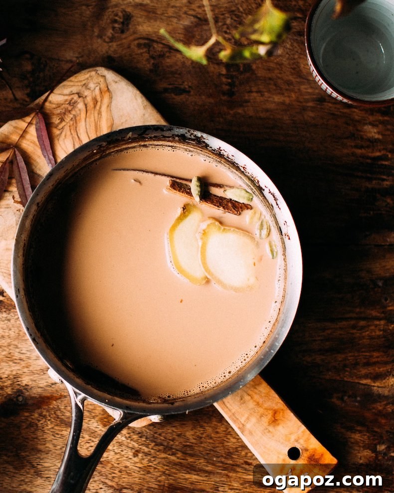 Warm & Festive: 20+ Easy Hot Drinks for a Perfect Christmas 5 Homemade chai tea brewing in a pot with whole Indian spices like cardamom, cinnamon, and cloves.