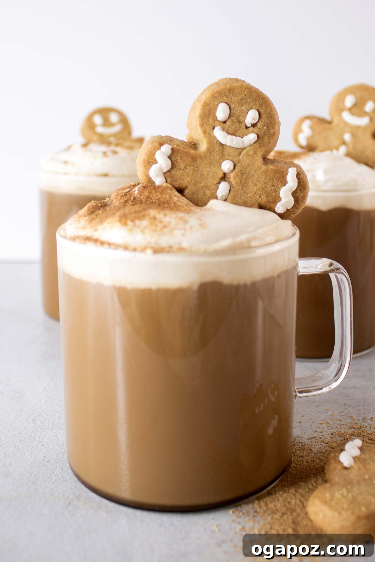 Warm & Festive: 20+ Easy Hot Drinks for a Perfect Christmas 8 Gingerbread Latte in a clear glass mug, topped with whipped cream and gingerbread cookie crumbs.