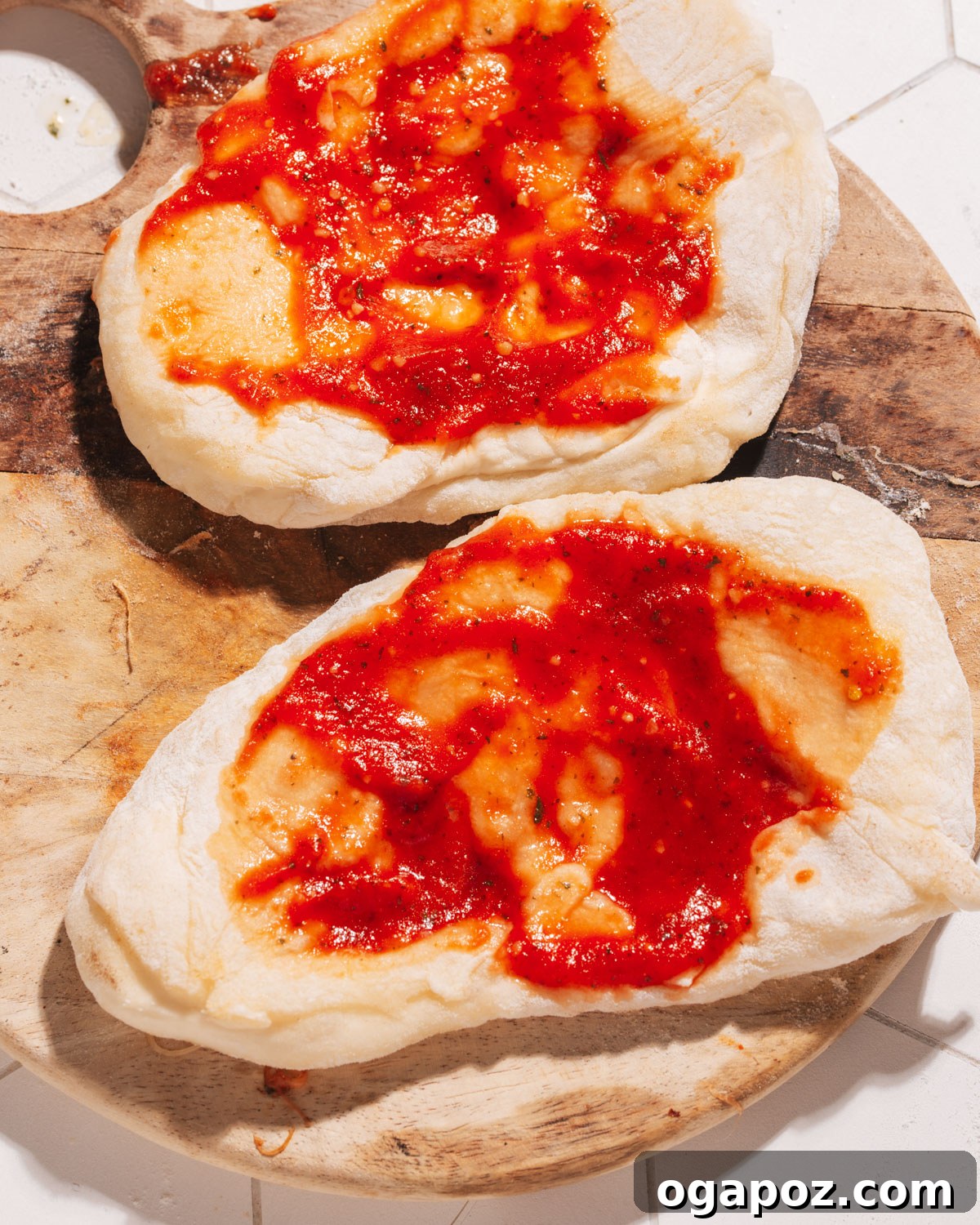10 Minute Flatbread Pizza Simple and Delicious 3 Pizza sauce spread on flatbread base.