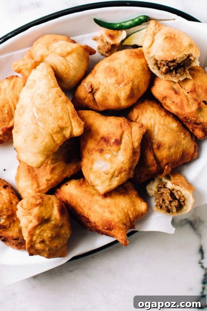 Simple Christmas Bites Everyone Craves 23 Chicken Samosas on a plate with one cut open.