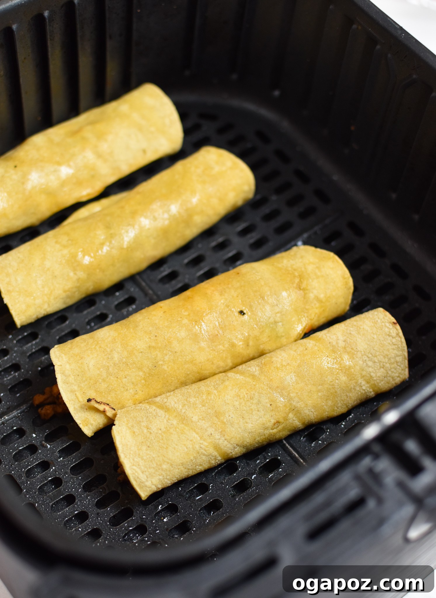 Crispy Air Fryer Pork Taquitos 6 Air Fryer basket filled with neatly rolled pork taquitos, ready for cooking and crisping.