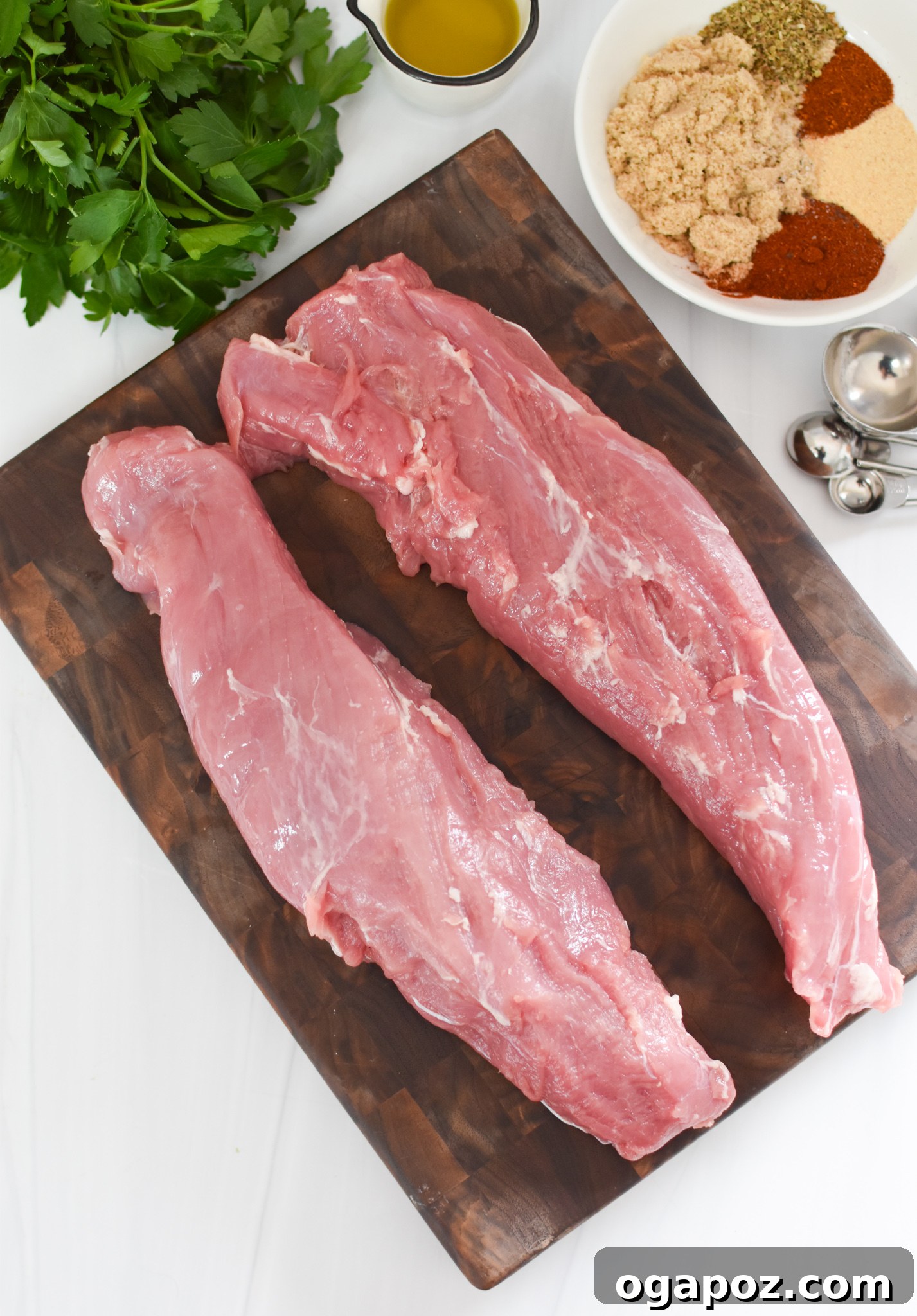 Golden Air Fryer Pork Tenderloin 3 Uncooked pork tenderloin on a cutting board, coated with the smoky sweet spice rub before air frying.
