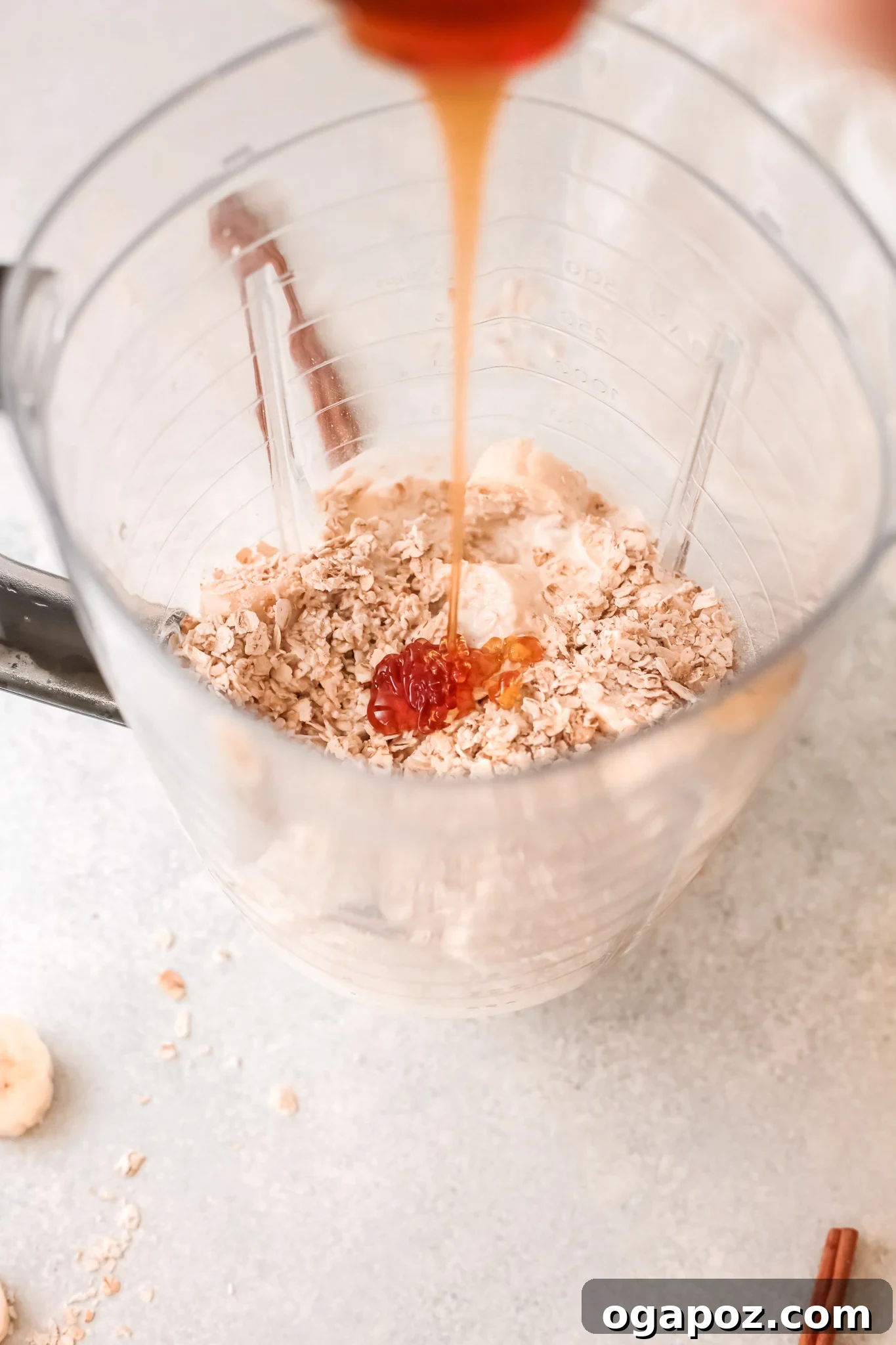 Quick & Healthy Oat Smoothies 6 A stream of honey being poured into the blender with other oat smoothie ingredients.